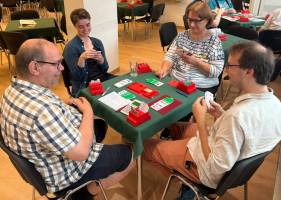 Beim Bridge spielen zwei Partnerschaften aus je zwei Personen gegeneinander. Die Partner sitzen sich gegenüber. Die Position am Tisch wird mit Nord, Ost, Süd und West bezeichnet. Hier befindet sich das Spiel in der Phase des Reizens. Mit strategischen Kniffen wird hier in einer Art Auktion geboten, welche Partnerschaft wie viele Stiche in welcher Farbe machen kann. Foto: Claudia Lüßmann